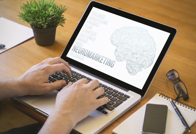 neuromarketing concept. Close-up top view of a man working on laptop. all screen graphics are made up.